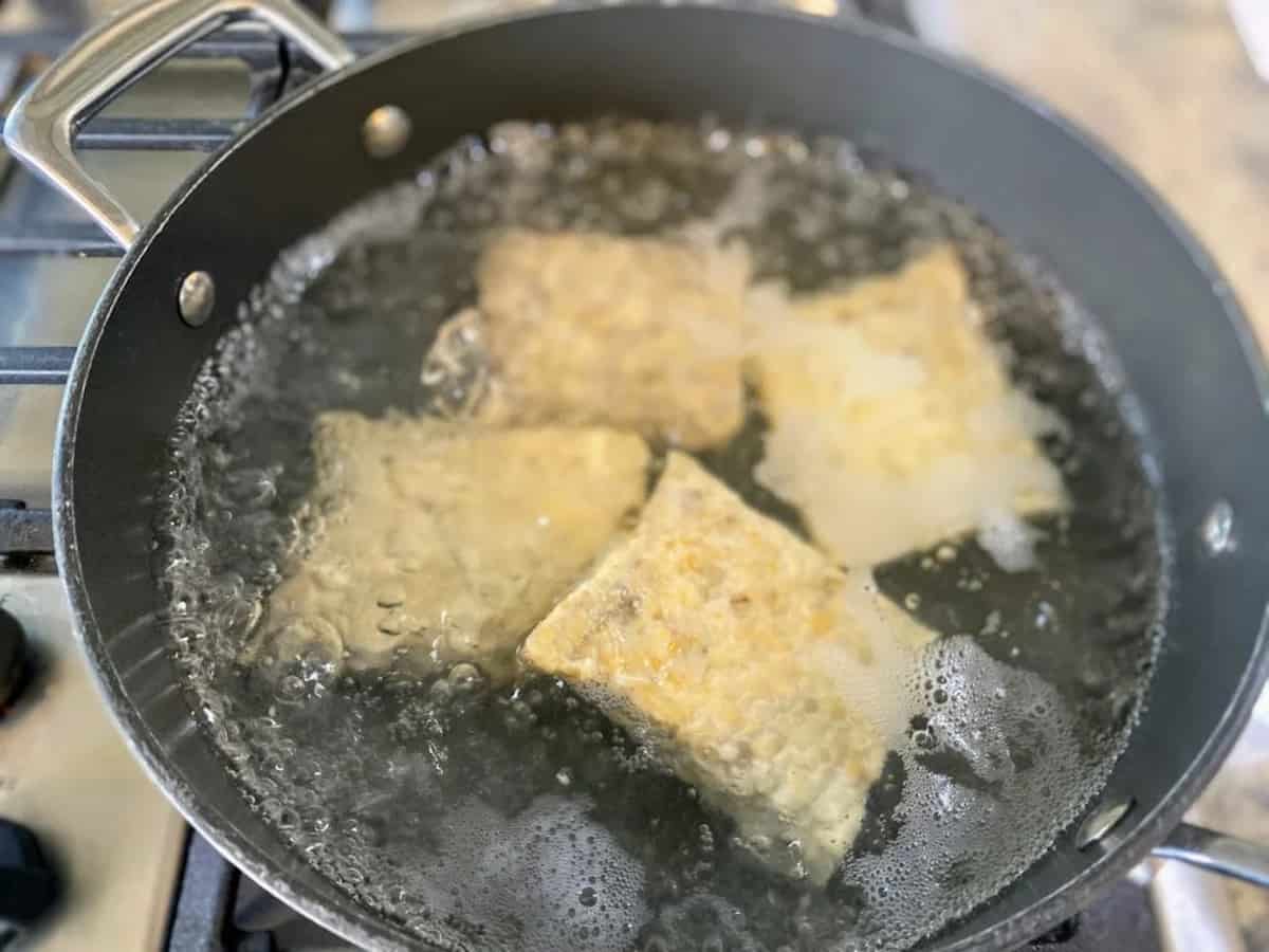 Tempeh prices boiling in a pan on the stove
