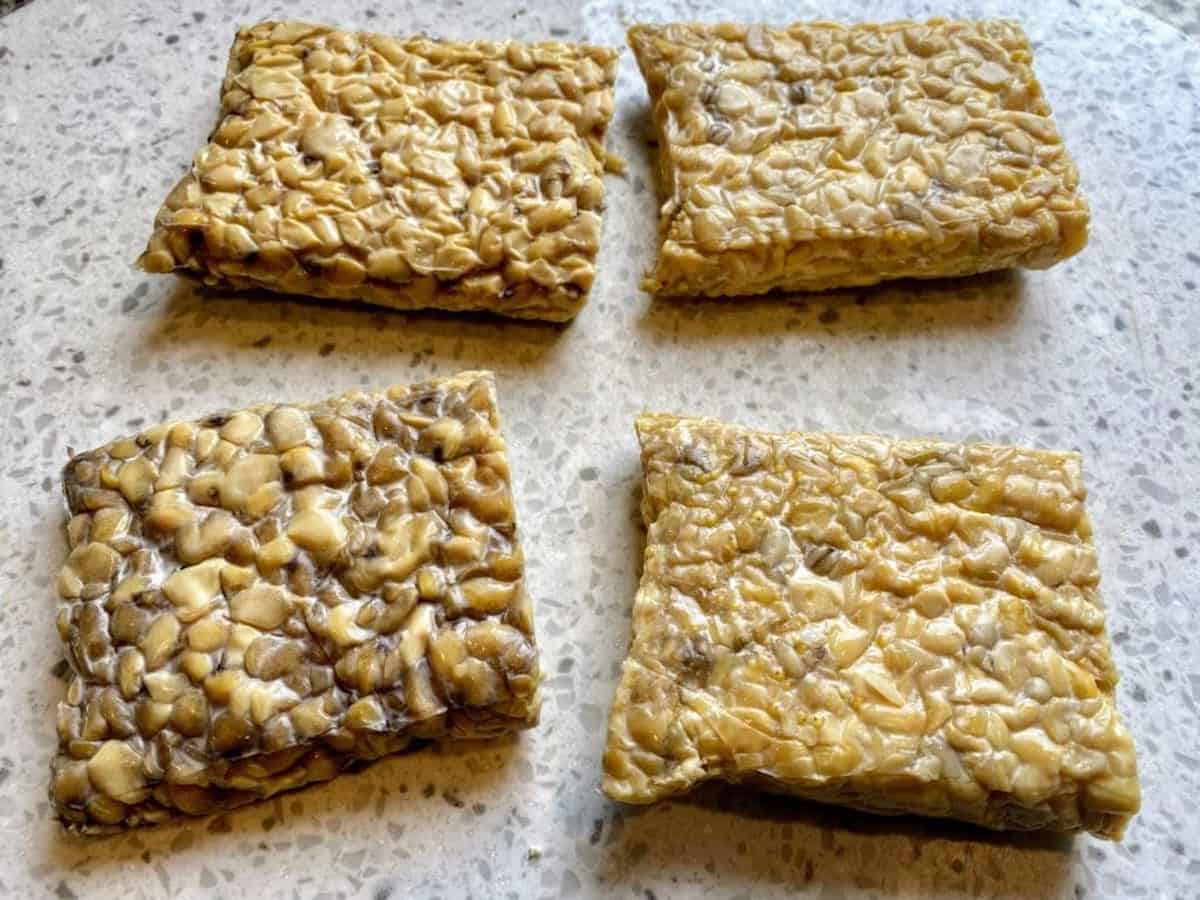 Tempeh removed from the package and cut into four equal sized pieces
on a cutting board