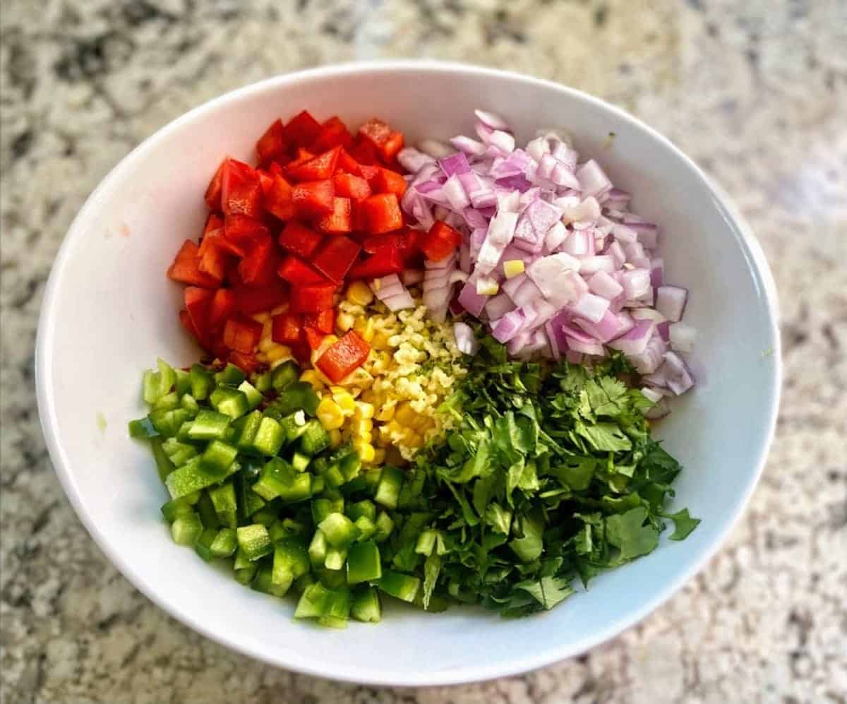 Corn salsa ingredients in a bowl on the counter