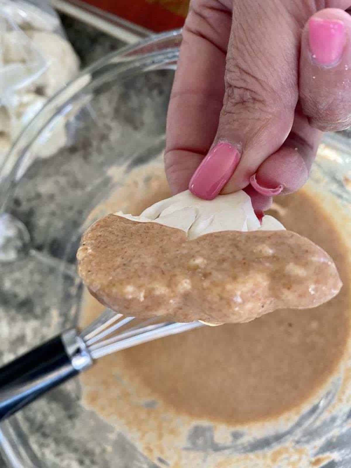 A cauliflower floret dipped in flour batter