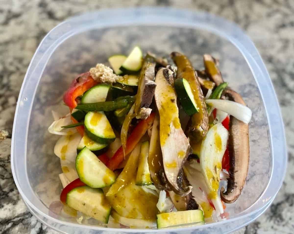 A bowl of marinated fajita vegetables on the counter.