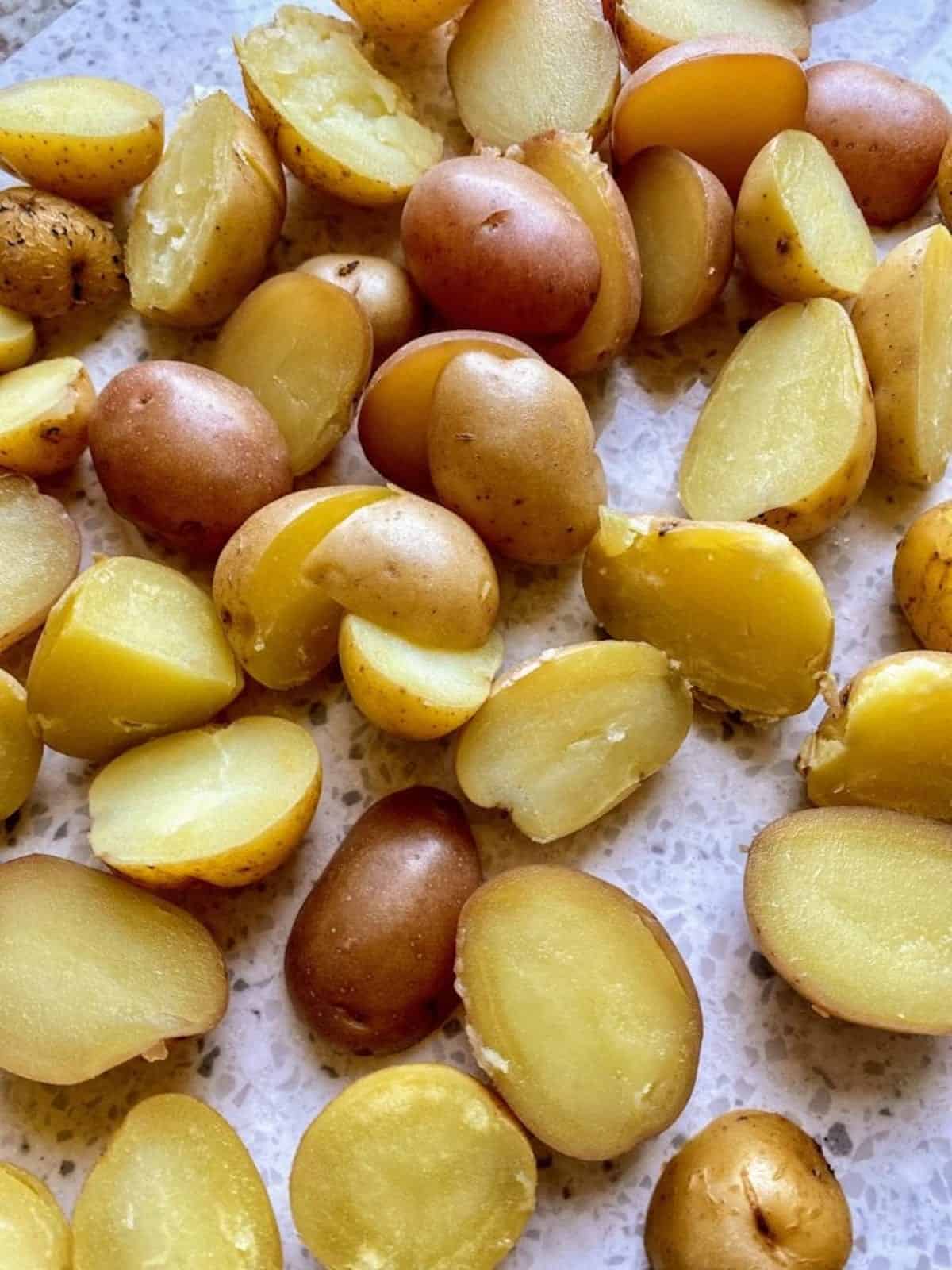 Baby potatoes cooked and cut on the cutting board