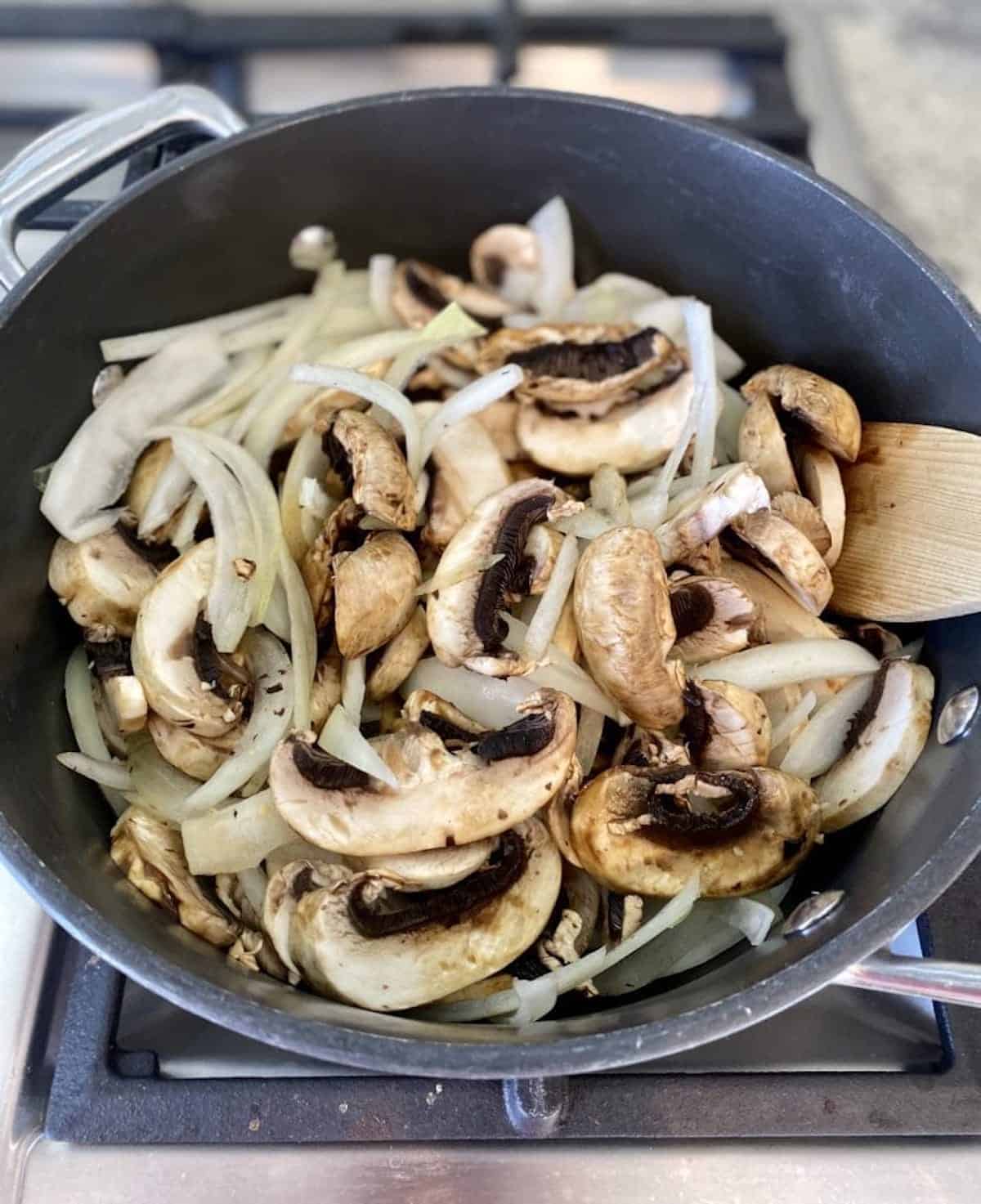 Garlic, onions, and mushrooms sautéing in a pot.