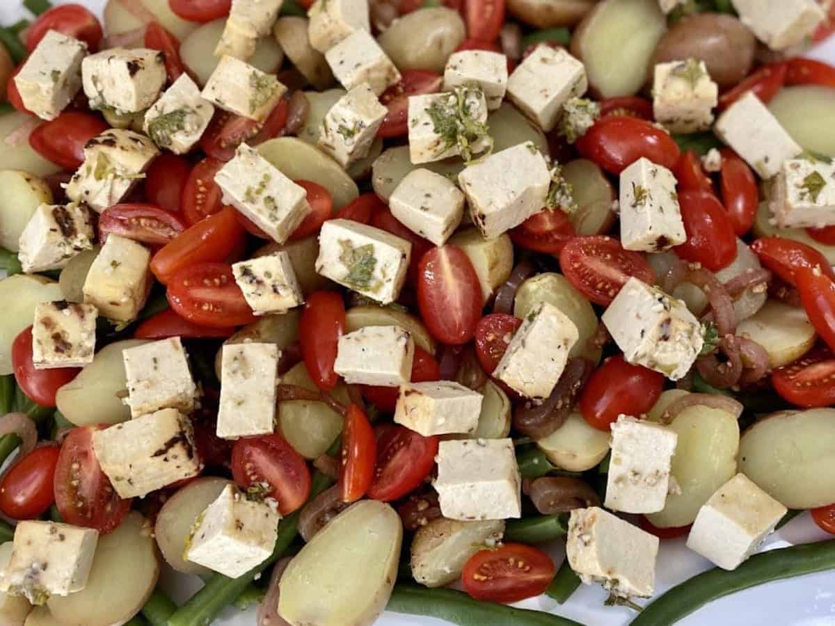 Green bean salad with baby potatoes green beans and balsamic onions, and grape tomatoes with tofu feta cheese