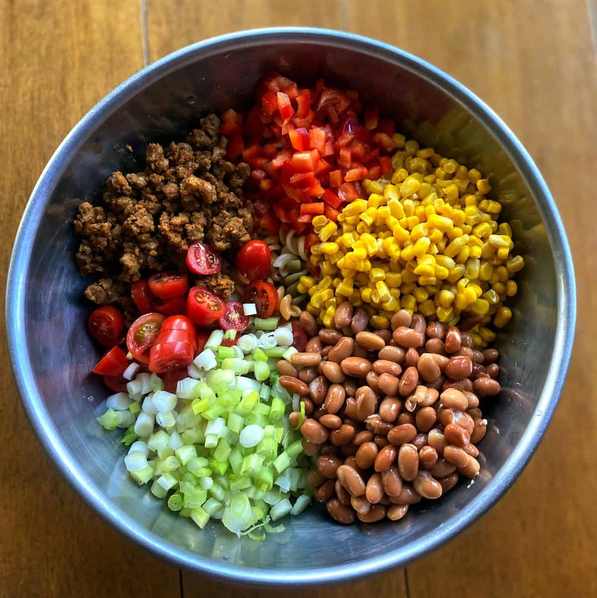 Taco pasta salad ingredients in a large bowl on the counter.