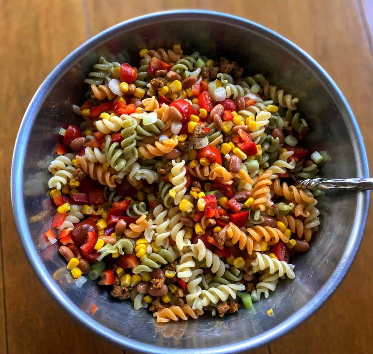 Taco Pasta Salad Recipe ingredients stirred together in a bowl.