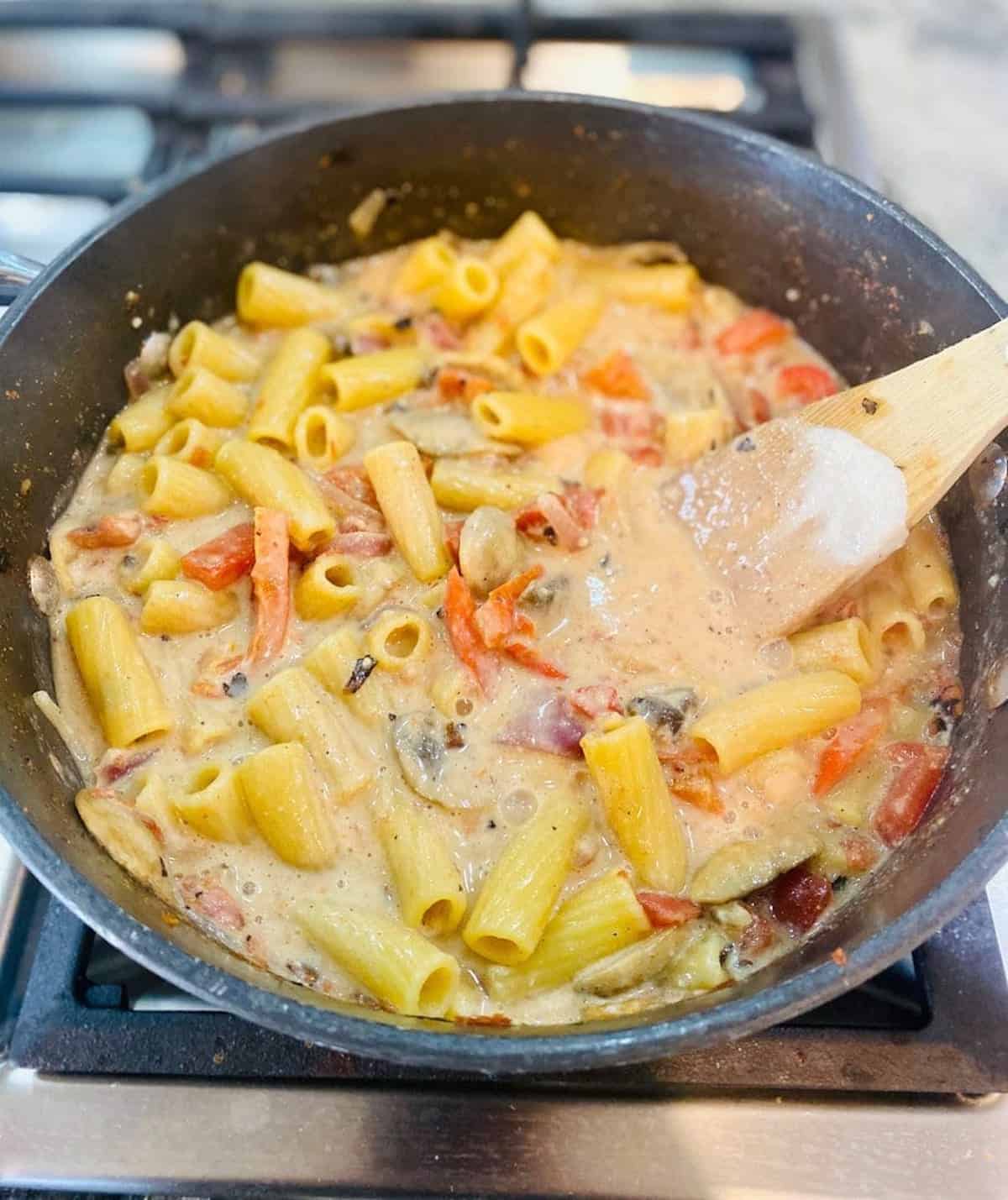 All the sauce to thicken in the pot of Cajun pasta recipe in the oven.