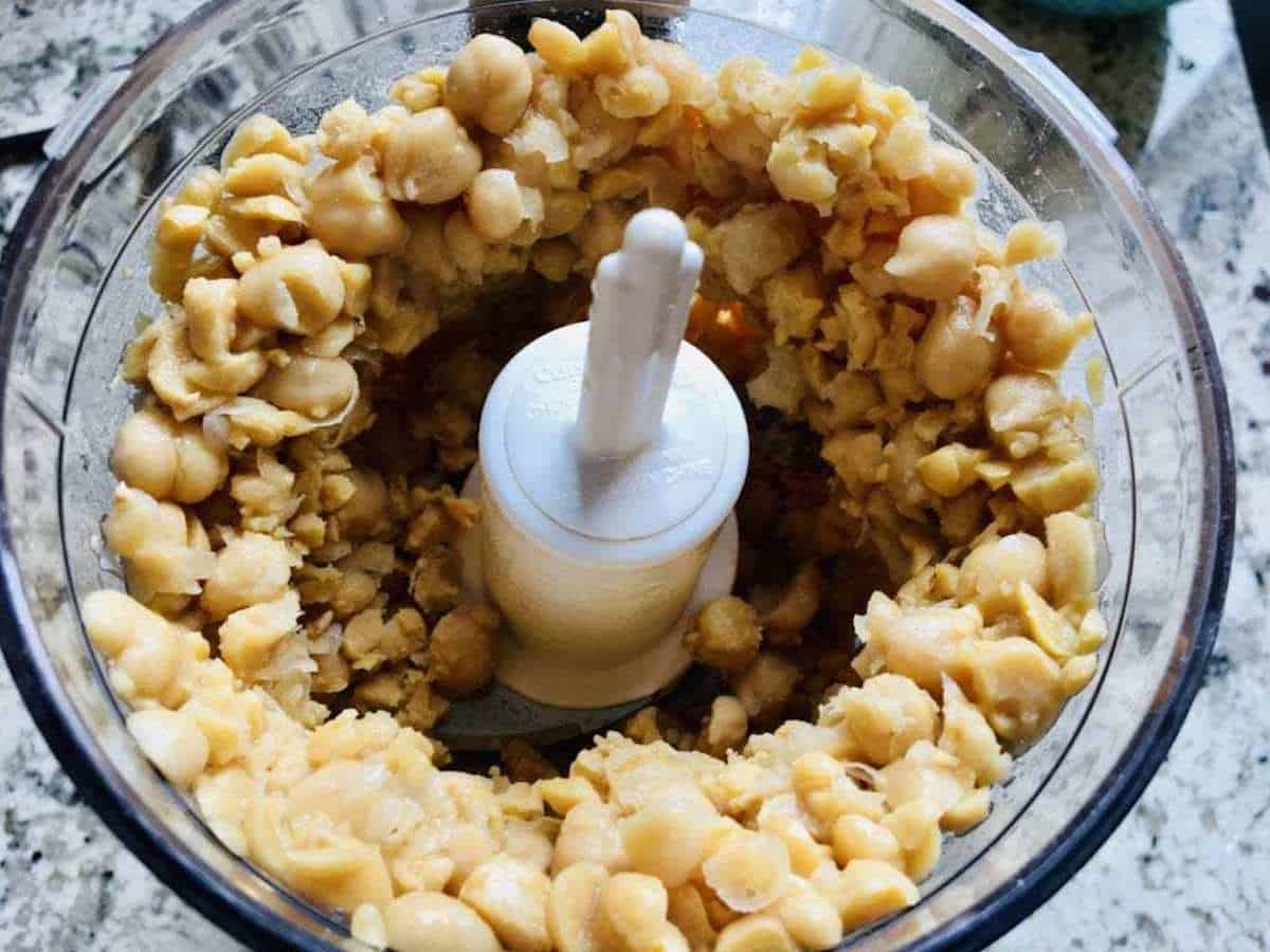 Chickpeas ground up in a small food processor bowl.