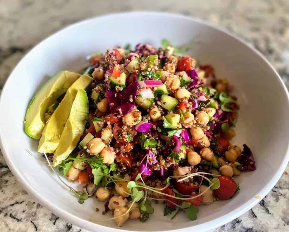 Chickpea Quinoa Salad with sliced avocado and microgreens.