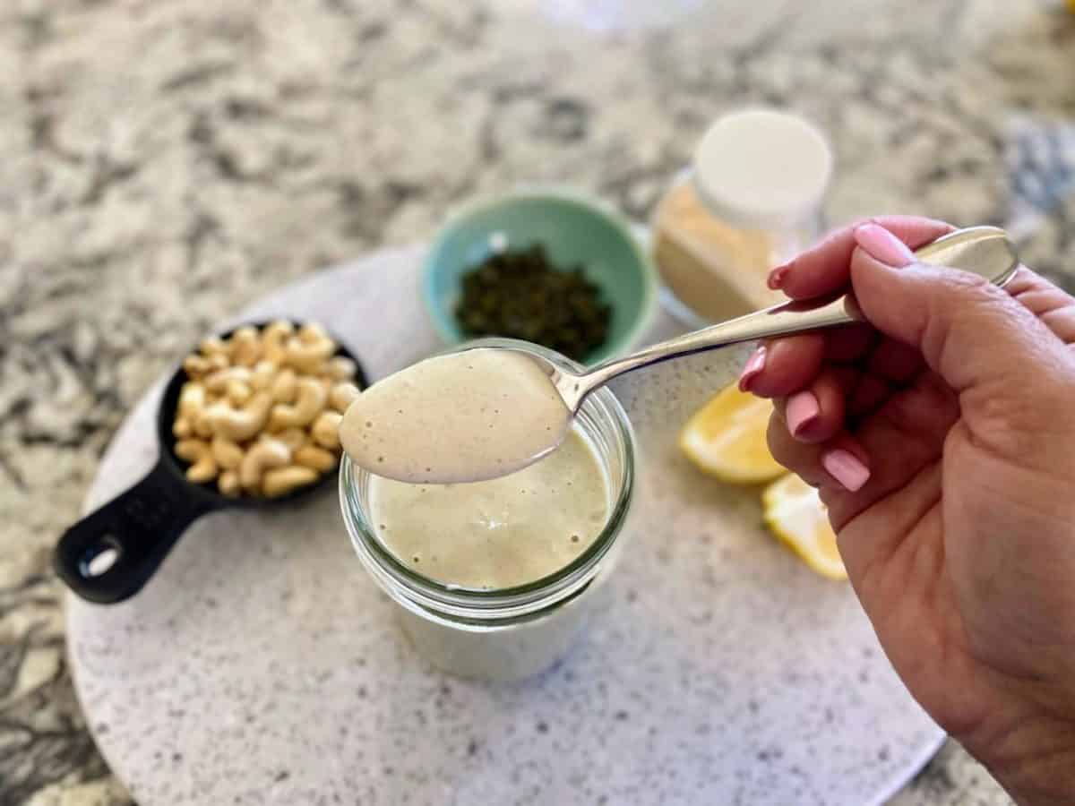 Dressing in a ball jar on the counter with ingredients in bowls in the background. 