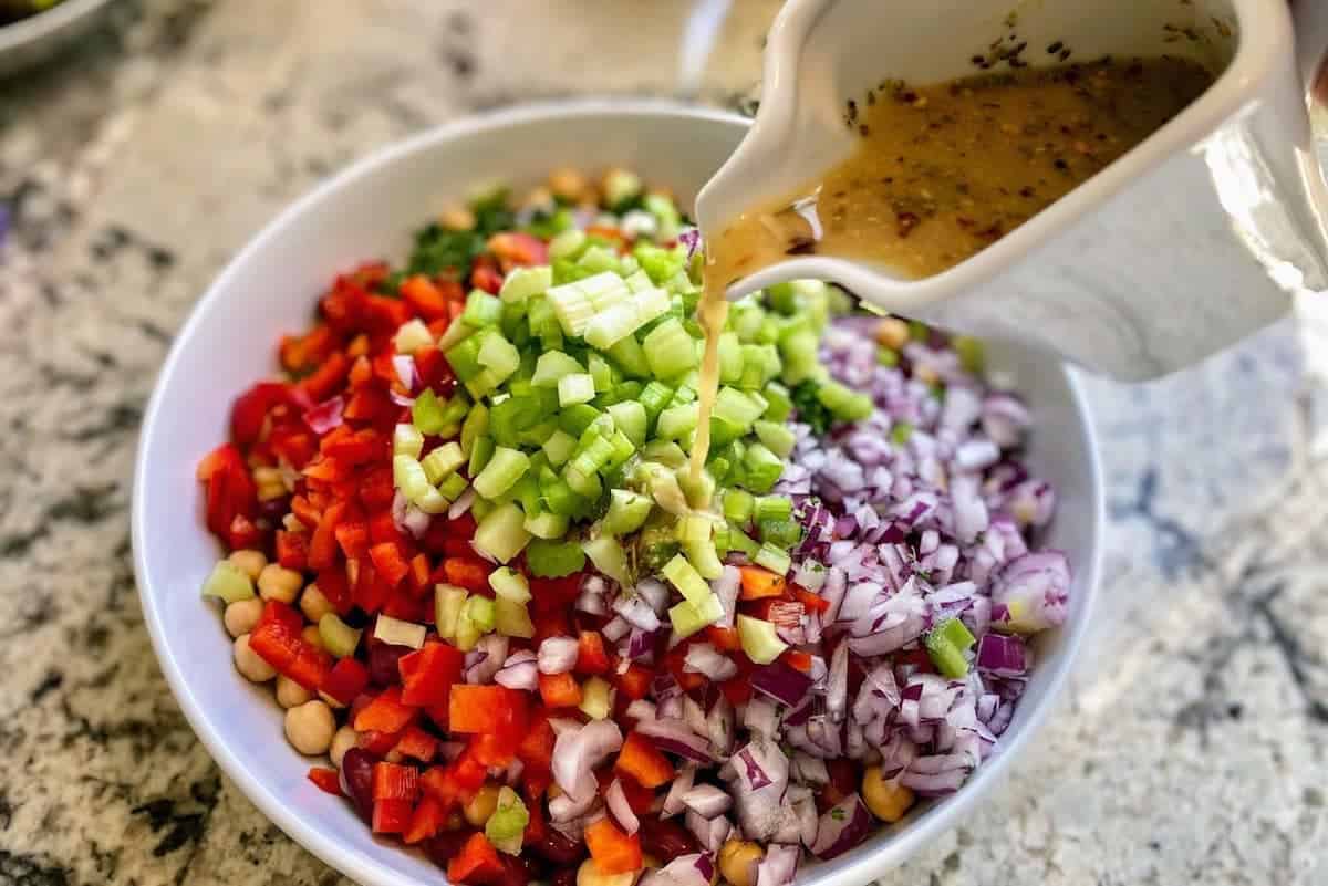 I pour the salad dressing into a bowl of ingredients.