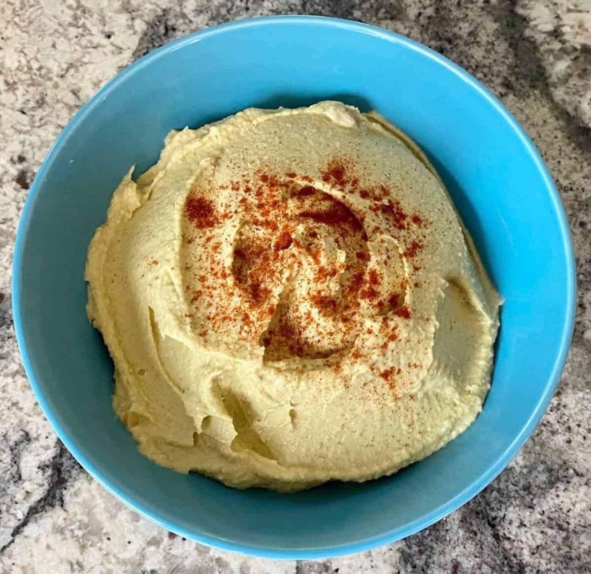 Avocado hummus recipe in a bowl on the counter.