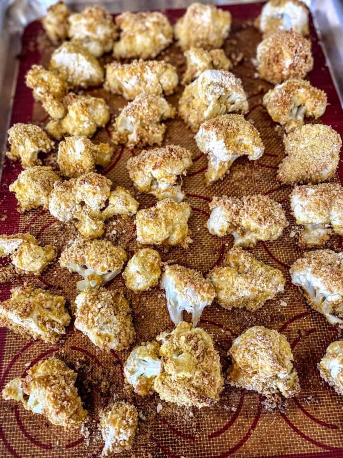 Breaded and baked cauliflower on a baking sheet.