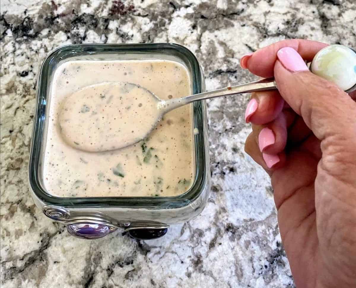 Vegan creamy Italian dressing in a bowl with a spoon. 