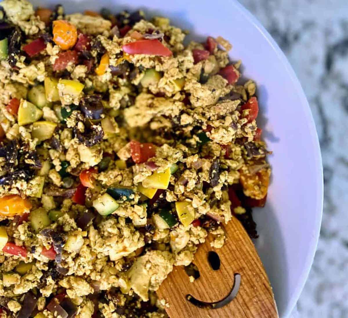 Mediterranean tofu scramble recipe in a bowl on the table.