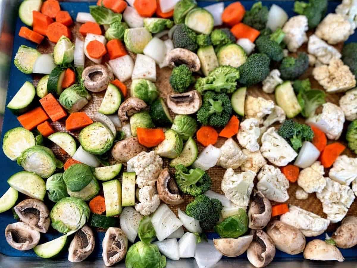 Vegetables on a baking sheet with seasoning. 