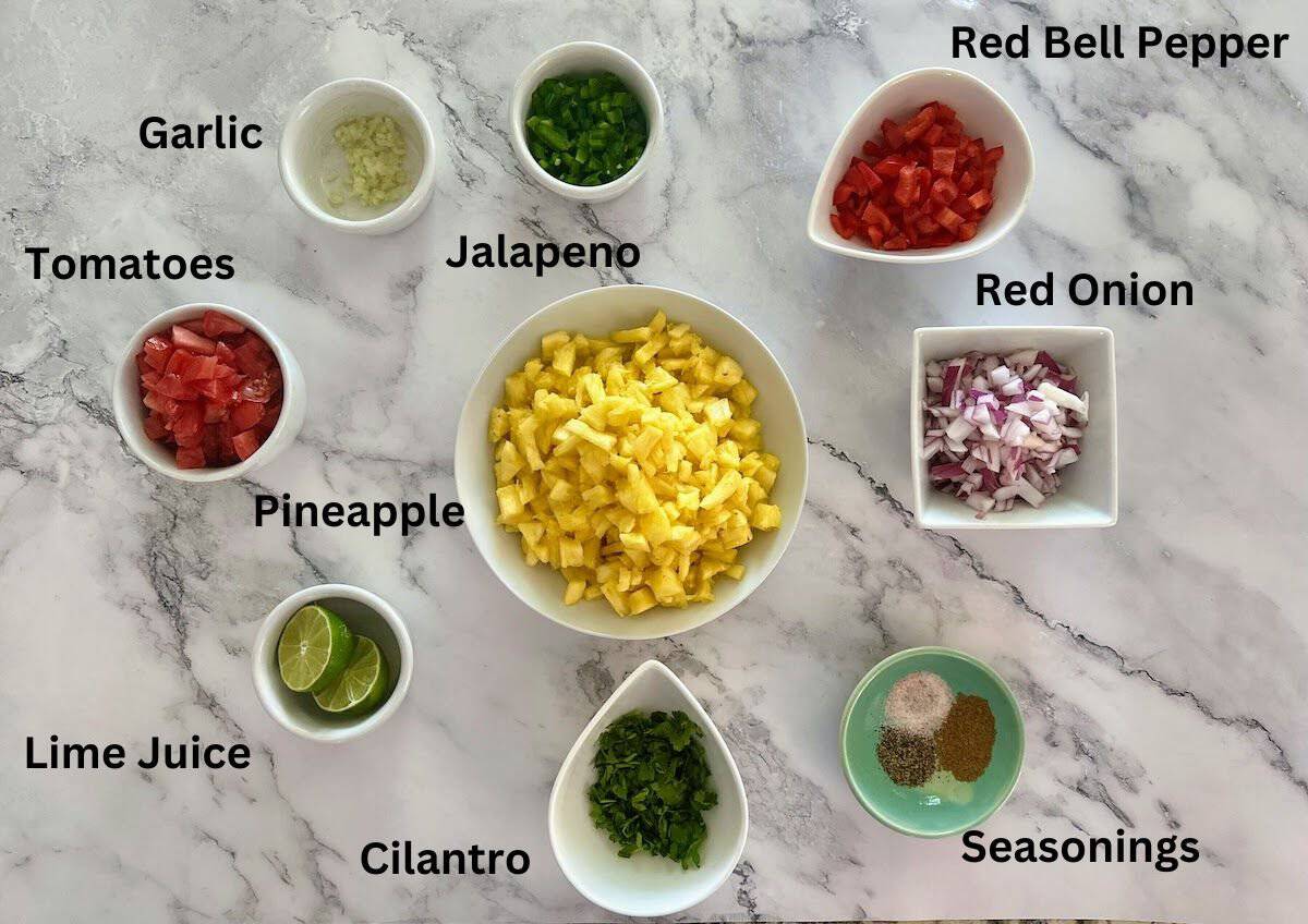 Pineapple salsa ingredients: pineapple, red bell pepper, red onion, salt, pepper, cumin, cilantro, lime juice, Roma tomatoes, garlic, and jalapeno