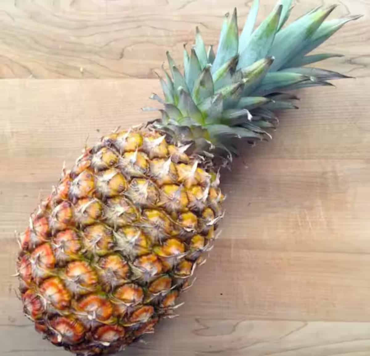 A pineapple was placed on a cutting board. 