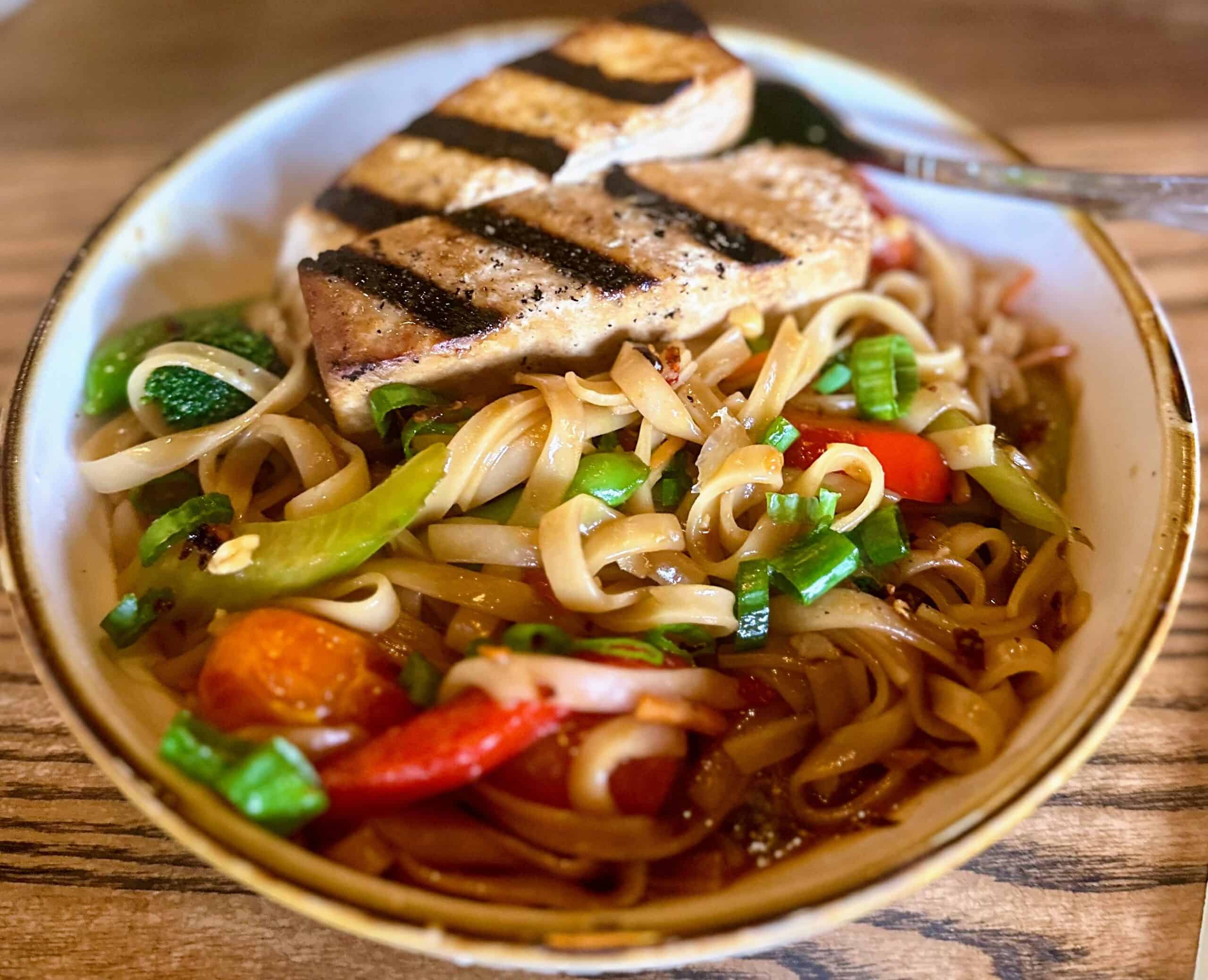 Grilled tofu on top of red curry noodles.