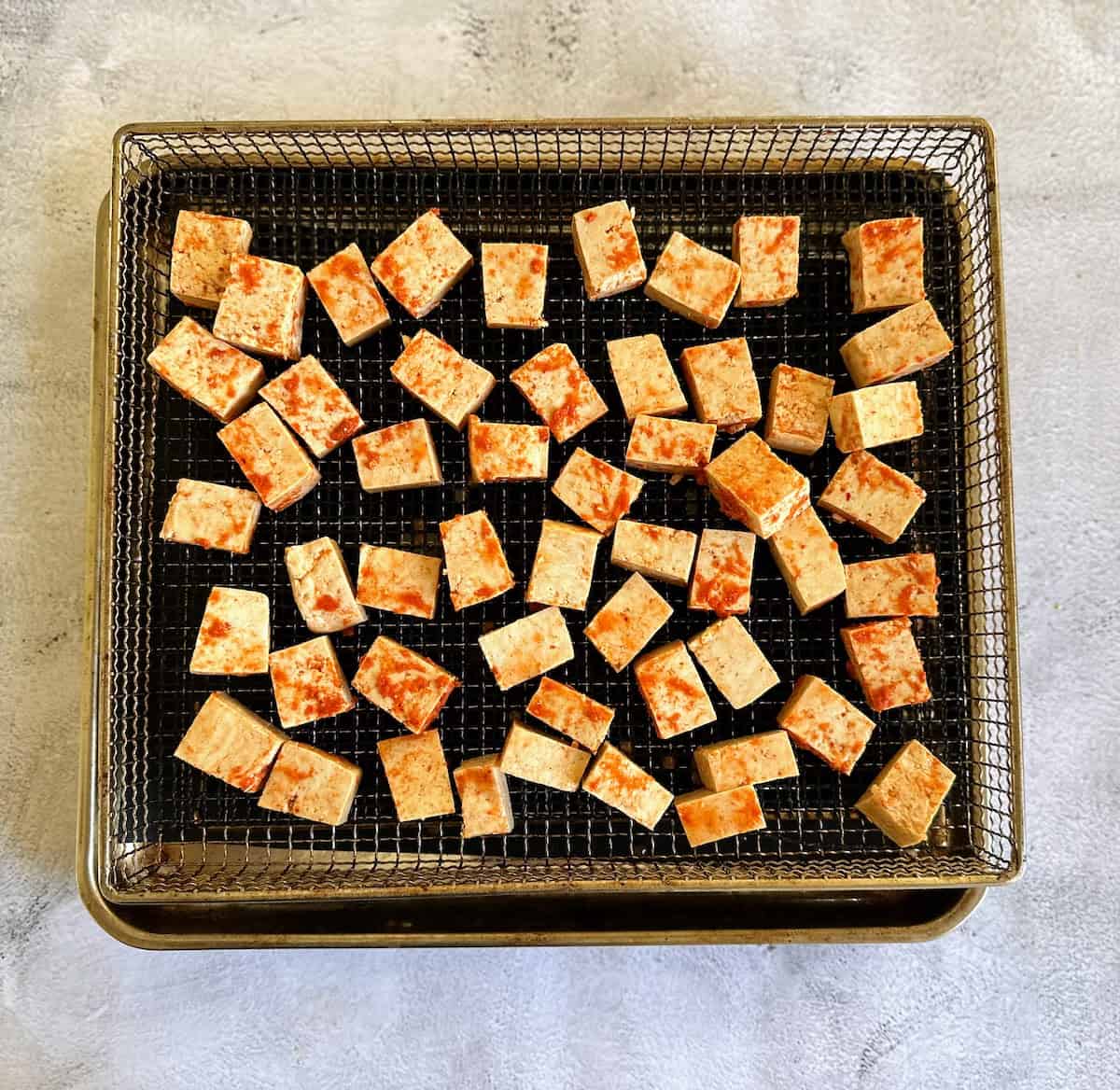 Marinated tofu on a air fry pan. 