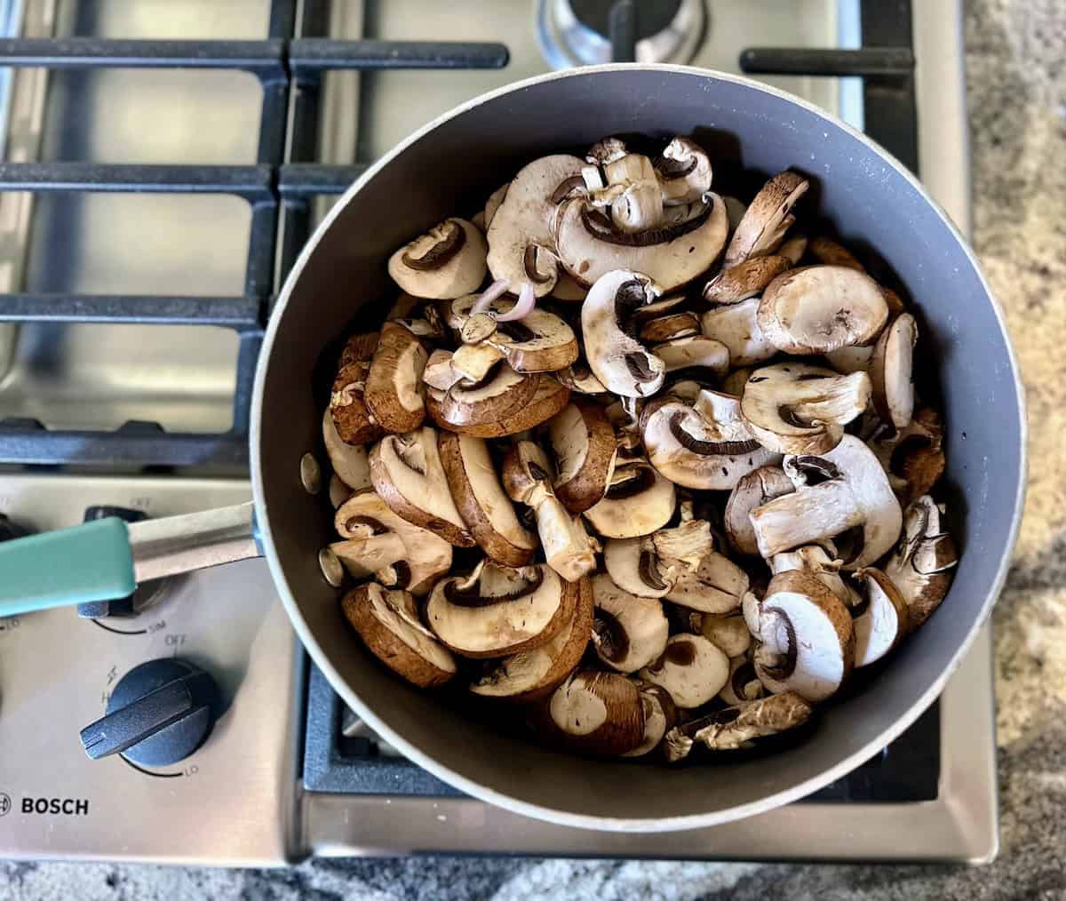 Mushrooms and shallots in a pan on the stove. 